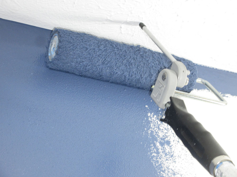 Roller painting a wall blue using the Roller watchdog attachment, a close-up of the roller and paint.